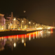 Verlichte grachtenpanden en reflecties in het water tijdens een heldere nacht in Leeuwarden.