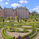 Barokke tuin met symmetrische hagen voor Paleis Het Loo in Apeldoorn, met Nederlandse vlag op het dak.